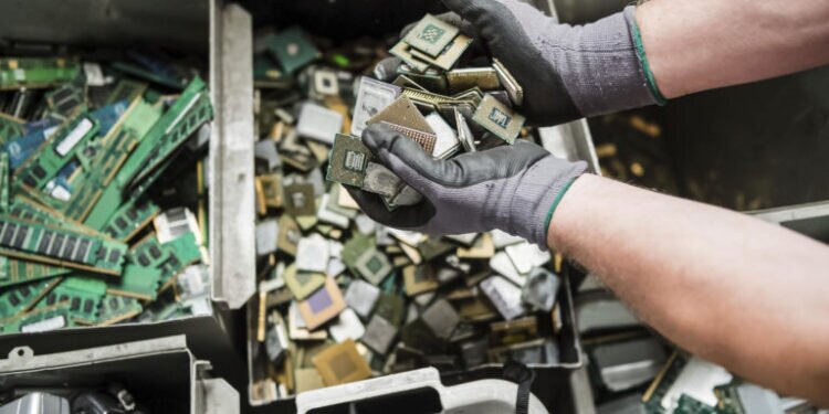 In this photo taken on July 13, 2018, a worker handles components of electronic elements at the Out Of Use company warehouse in Beringen, Belgium. Out Of Use dismantles computer, office and other equipment and recuperates an average of around 90 percent of the raw materials from electronic waste. (AP Photo/Geert Vanden Wijngaert)