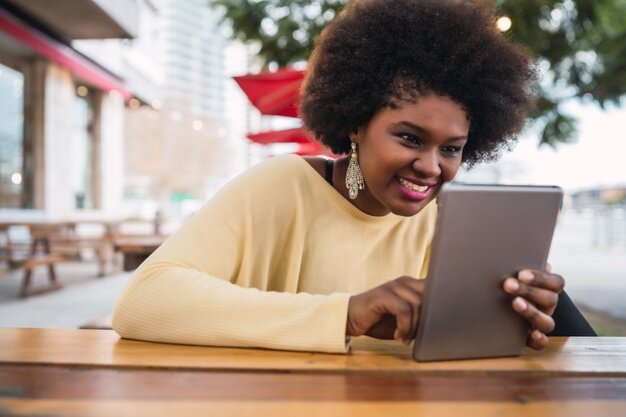 portret van een jonge afro amerikaanse latijns vrouw met behulp van haar digitale tablet tijdens de vergadering in de coffeeshop technologie concept 58466 12269