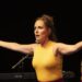 Gods Wegen Foto 3 scaled Iedereen die ooit naar het theater is geweest, weet dat  anderhalf uur zitten soms een beetje ‘saai’ of monotoon kan aanvoelen. Zeker als het gaat om een monoloog. Maar met ‘Van Gods wegen’ van theatermaakster Nina de la Parra kom je in een adembenemende rollercoaster terecht. Een stroom van woorden, muziek, de melodieuze stem van Nina, is het een permanent ‘zitten op de rand van je stoel’-soort voorstelling.