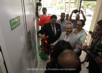 Doorknippen lint operatiekamer door John Frank de Bye Het ’s Lands Hospitaal is drie modern ingerichte zorgafdelingen rijker. Het gaat om de gerenoveerde operatiekamers, de Neonatale High Care Unit en de Endoscopie Unit. Op donderdag 11 mei 2023 kreeg president Santokhi bij de ingebruikname een rondleiding door deze afdelingen.