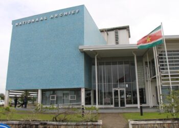 Het gebouw van het Nationaal Archief Suriname. Foto Biza DNA-lid Rabin Parmessar heeft dinsdag een schandaal van miljoenen uit de doeken gedaan in het parlement. "Voor het leveren van server apparatuur ten behoeve van het Nationaal Archief Suriname is voor de hoogste inschrijver gekozen." "Hiermee is de staat voor miljoenen benadeeld", deelde de NDP-topper mee.