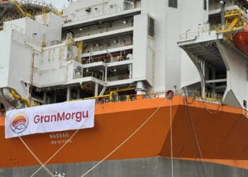 A large orange and white ship with a banner on it.