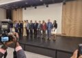 A group of people standing on a stage with a camera.
