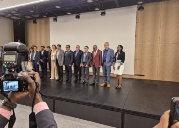 A group of people standing on a stage with a camera.