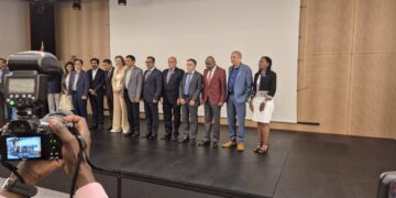 A group of people standing on a stage with a camera.
