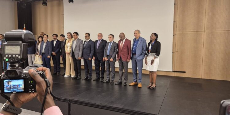 A group of people standing on a stage with a camera.