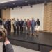 A group of people standing on a stage with a camera.