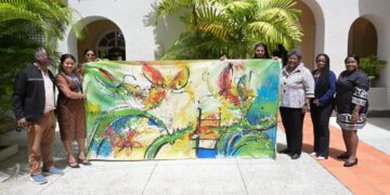 df84fcda c116 47a7 b9e6 8634564335a4 1536x1024 1 De Surinaamse delegatie die deelneemt aan Carifesta XV op Barbados heeft een beleefdheidsbezoek gebracht aan premier Mia Amor Mottley. Tijdens de ontmoeting werd een speciaal vervaardigd canvas schilderij van kunstenaar George Struikelblok officieel aan de premier aangeboden...