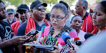 De directeur van de VIDS, France Cylene leest de resolutie voor president Jennifer Simons | Foto kabinet president