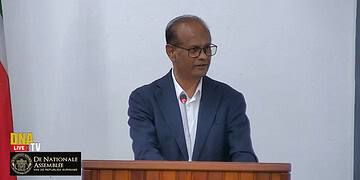 Screenshot 2025 11 11 140340 NDP-fractieleider Rabin Parmessar heeft tijdens de Algemene Politieke Beschouwingen (APB) felle kritiek geleverd op het gebrek aan controle en daadkracht binnen de goudsector. Hij stelt dat er relatief weinig inkomsten uit de kleinschalige goudwinning in de staatskas terechtkomen, terwijl de exportvolumes dalen. Volgens Parmessar is dat reden om het hele opkoop- en exportproces van goud grondig te hervormen.