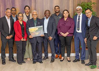 65f1a6b4 6cd6 4500 8a8a 8ee93fa46448 President Simons overhandigde het eerste exemplaar van de Geologische Atlas aan Eddy Jharap, ter ere van 45 jaar Staatsolie. Ontdek meer over deze bijzondere gebeurtenis