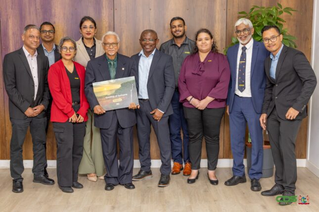 65f1a6b4 6cd6 4500 8a8a 8ee93fa46448 President Simons overhandigde het eerste exemplaar van de Geologische Atlas aan Eddy Jharap, ter ere van 45 jaar Staatsolie. Ontdek meer over deze bijzondere gebeurtenis