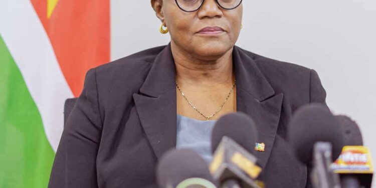 0a2f1f9a dca0 4f95 8cf5 e4ea6f35b0f2 e1772294228518 De jaarinflatie is in 2025 gestegen naar 11,4%, tegenover 10% in 2024. Minister Adelien Wijnerman van Financiën en Planning zegt dat hogere tarieven en duurdere voeding de prijsdruk aanjagen, terwijl de hogere goudprijs tegelijk extra staatsinkomsten en grotere internationale reserves oplevert.