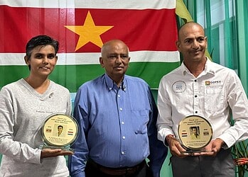 WhatsApp Image 2026 03 02 at 8.14.35 AM Tijdens de Holiviering heeft Satya Dharma de heer Bhiesnoe Gopal en mevrouw Ranu Abhilak onderscheiden met de Surinaams-Rotterdamse Speld (SuRo Speld). De onderscheiding werd opgespeld door Koemar Khargi, president van Satya Dharma Nederland–Suriname.